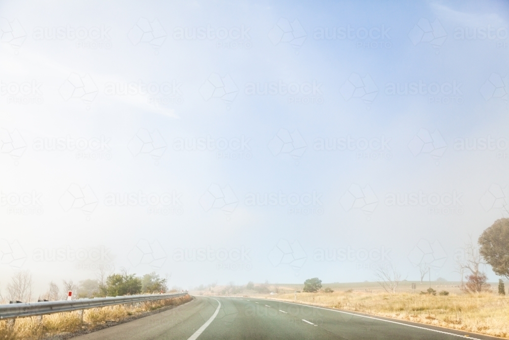 Changing weather conditions on highway sunlight and fog - Australian Stock Image