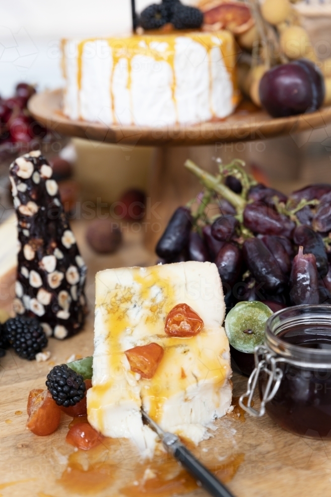 cheese board filled with cheeses and fruits - Australian Stock Image