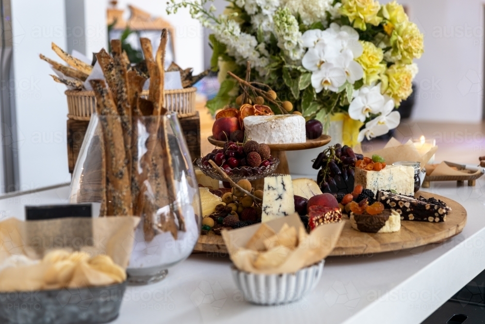 cheese board filled with cheeses and fruits - Australian Stock Image