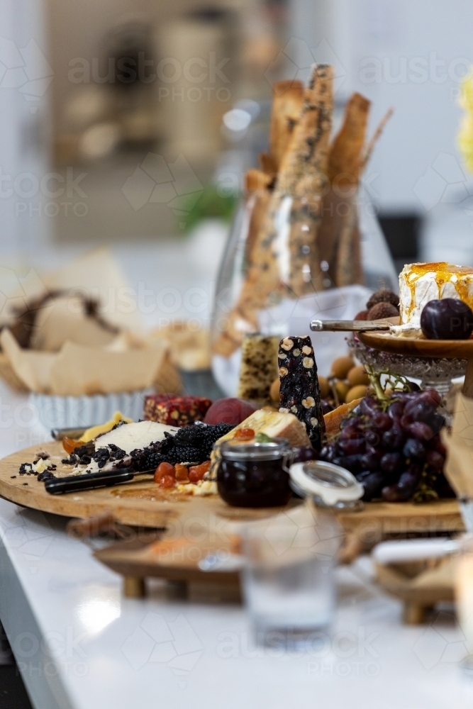 cheese board filled with cheeses and fruits - Australian Stock Image