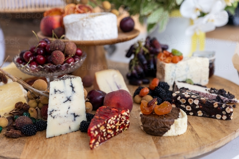 cheese board filled with cheeses and fruits - Australian Stock Image