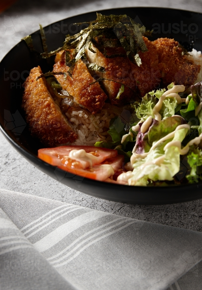 Chicken katsu on rice with salad - Australian Stock Image
