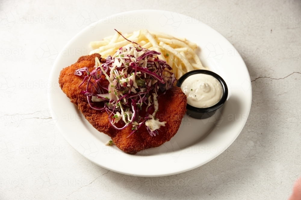 Chicken schnitzel with fries dish - Australian Stock Image