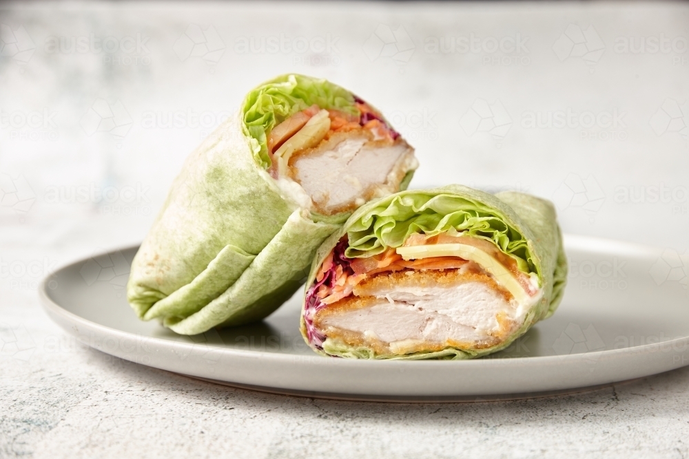 Chicken vegetable wrap on a white plate - Australian Stock Image