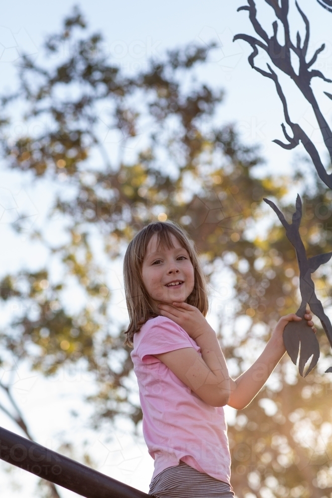 Child climbing on a fence in the outback - Australian Stock Image