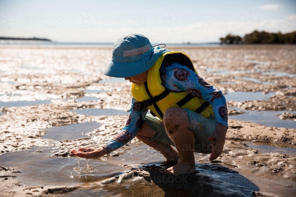 child exploring tide pools on Moreton Bay - Australian Stock Image