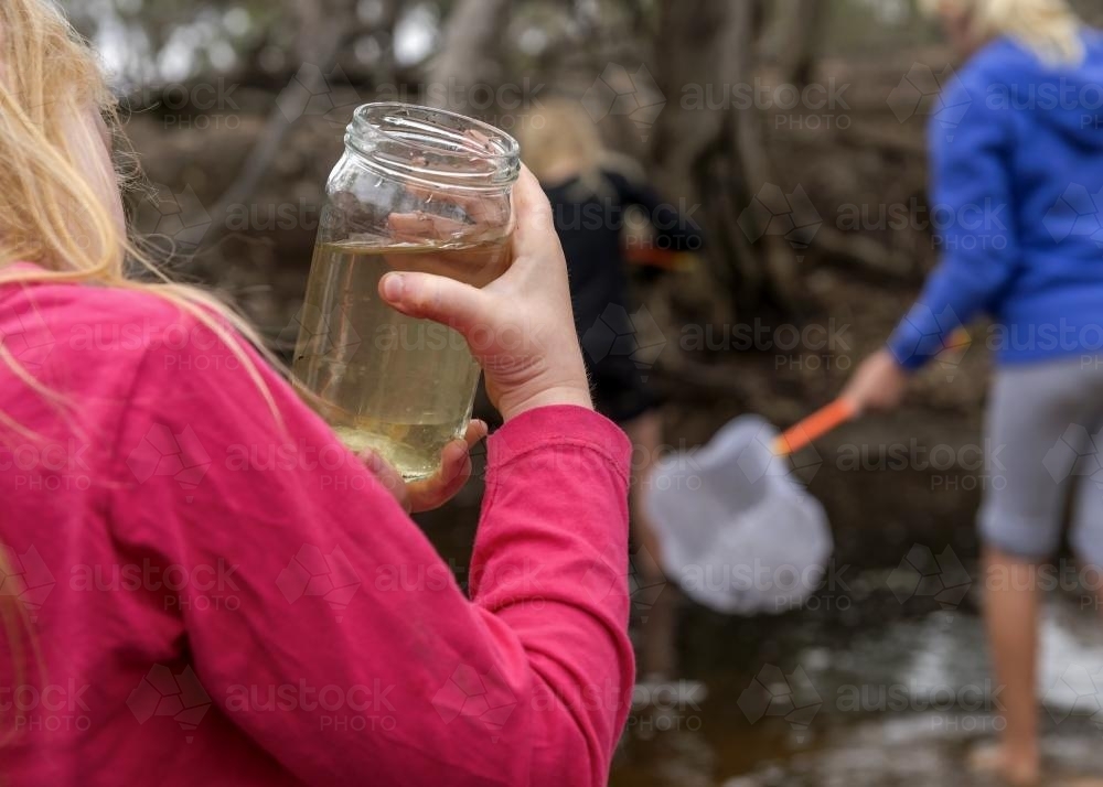 Child Holiding Jar of Tadpoles - Australian Stock Image