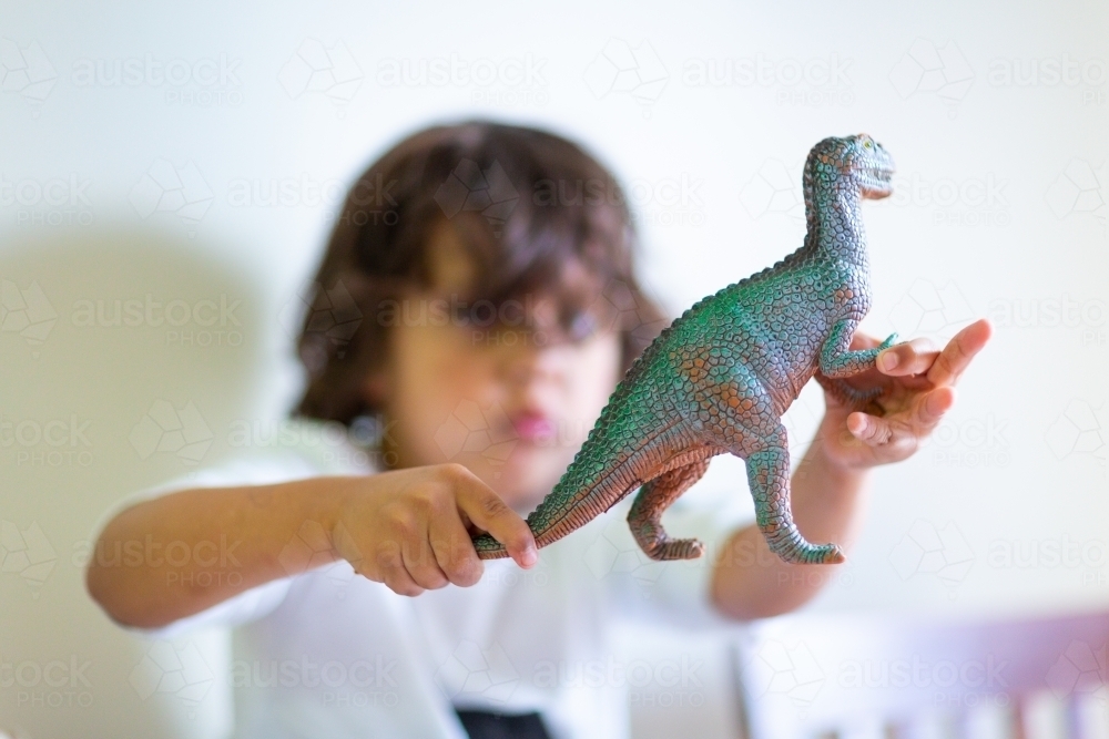 Child playing with a plastic dinosaur - Australian Stock Image