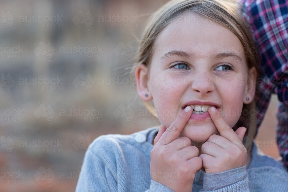 Child pointing to two front teeth - Australian Stock Image