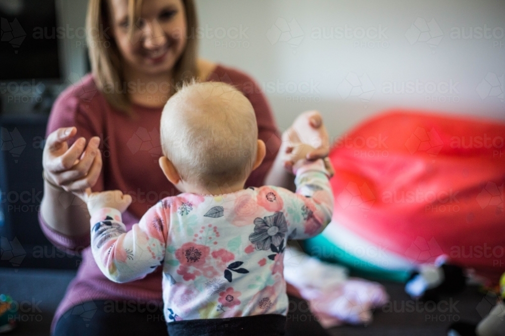 Child walking towards mother holding hands - Australian Stock Image