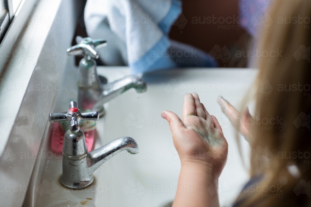 Child washing hands at old-fashioned sink - Australian Stock Image