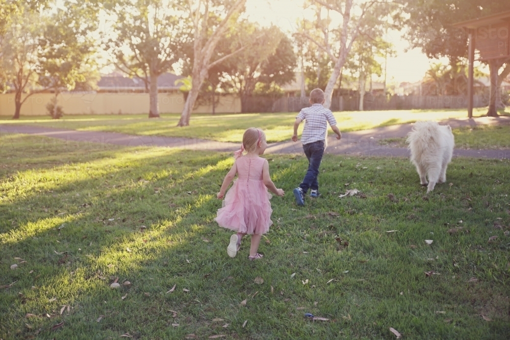 Children and dog playing in the park - Australian Stock Image