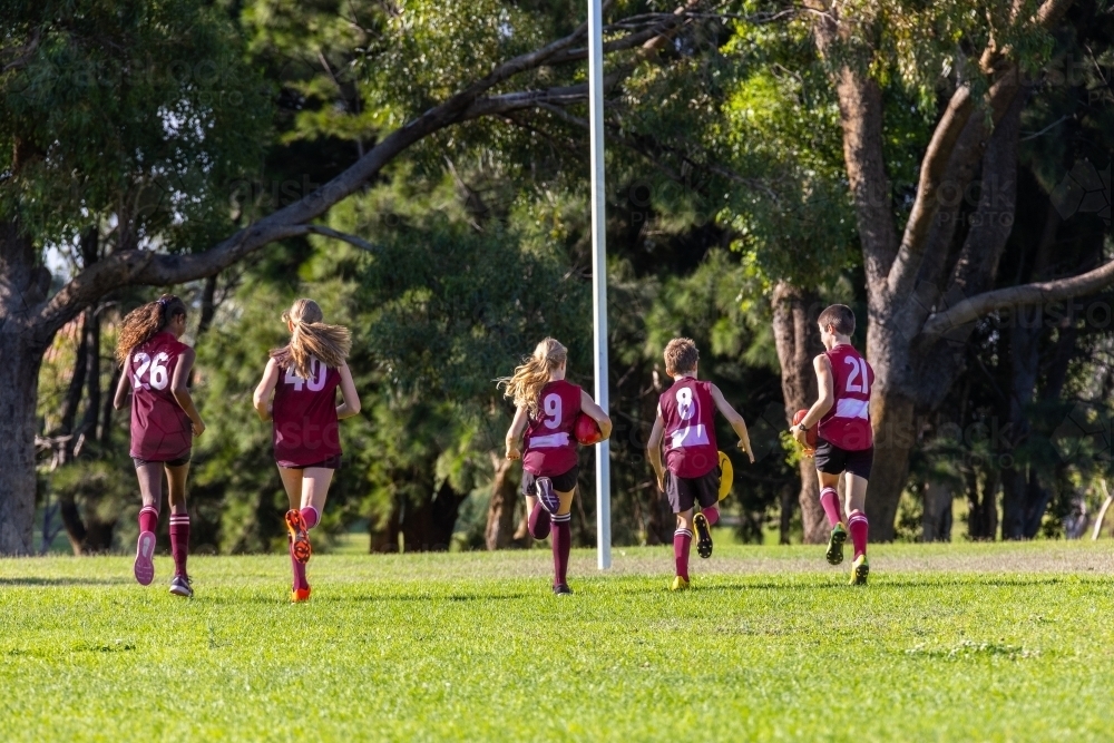 children running away on football oval - Australian Stock Image