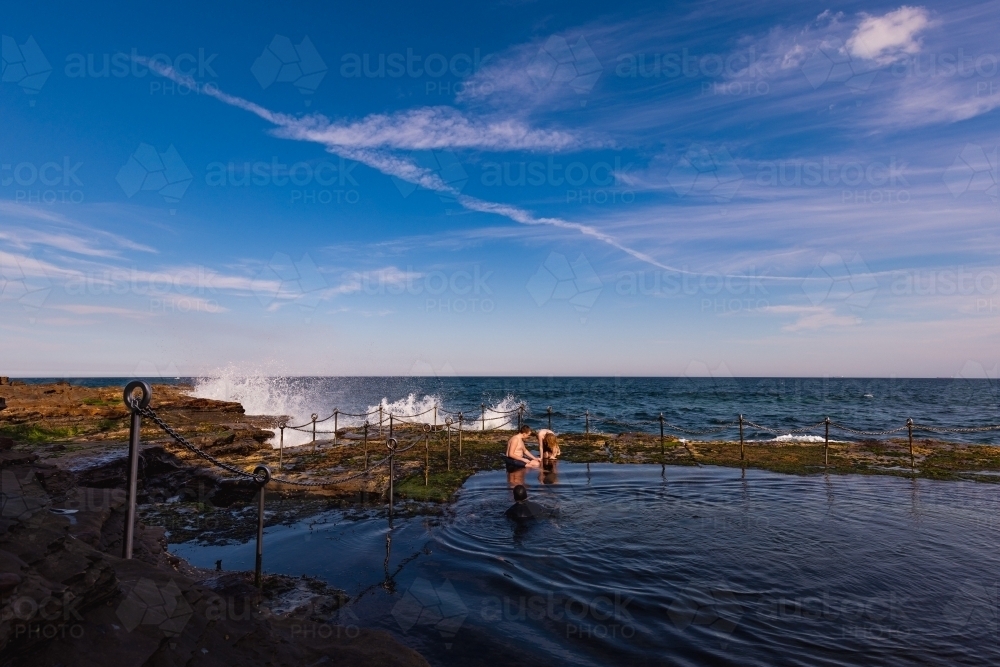 Children swimming in the Bogey Hole, historic man-made rock pool in Newcastle NSW - Australian Stock Image