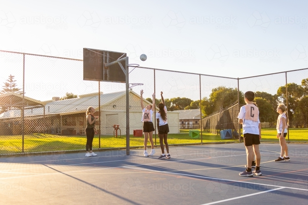 children training for netball on outdoor court - Australian Stock Image