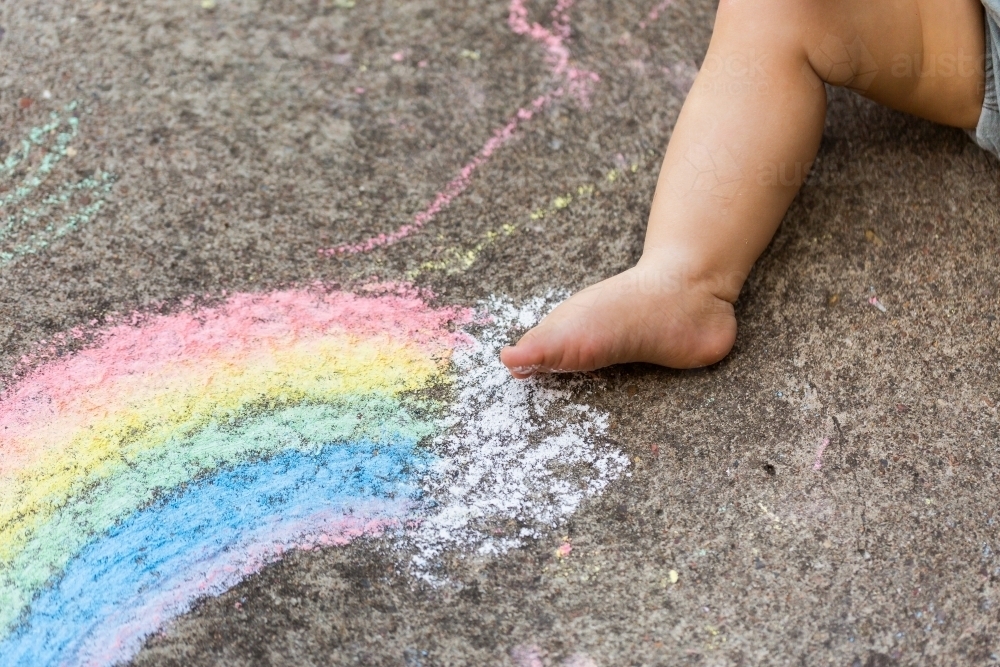 Childs foot on concrete with chalk drawing - Australian Stock Image