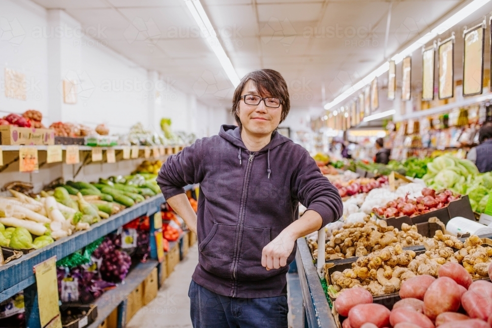 Chinese man working in fresh food store - Australian Stock Image