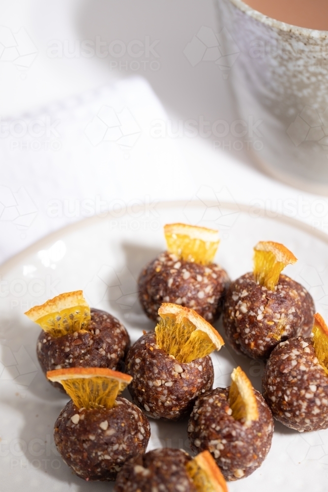 Chocolate protein balls on a white kitchen bench - Australian Stock Image