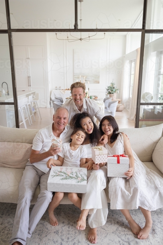 Christmas family photo on couch with presents - Australian Stock Image