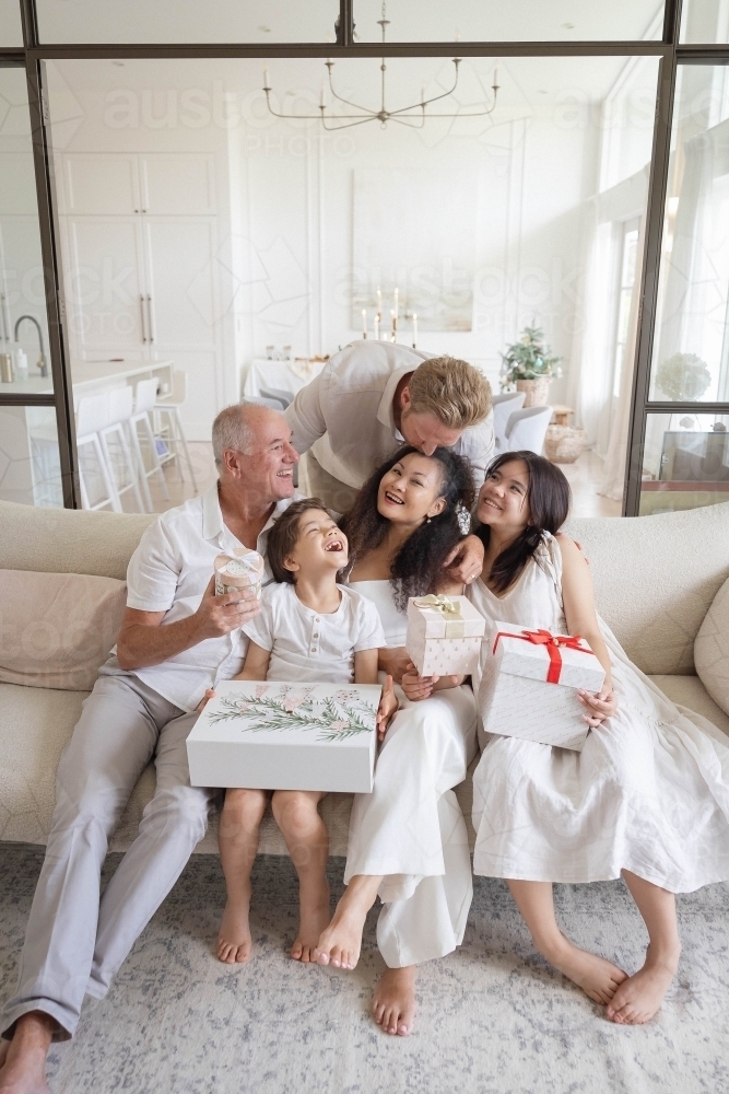 Christmas family photo on couch with presents - Australian Stock Image