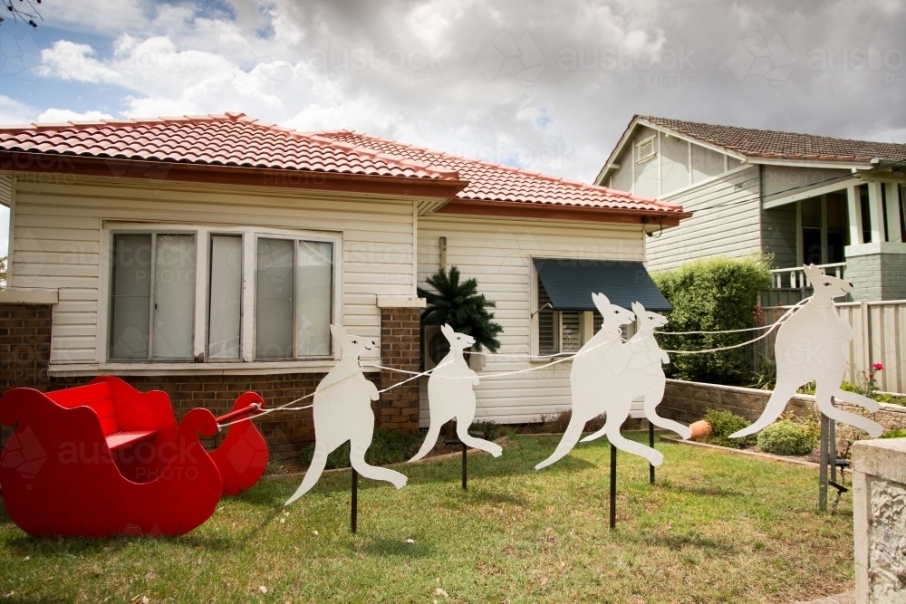 Christmas sleigh and kangaroo decorations outside a house - Australian Stock Image