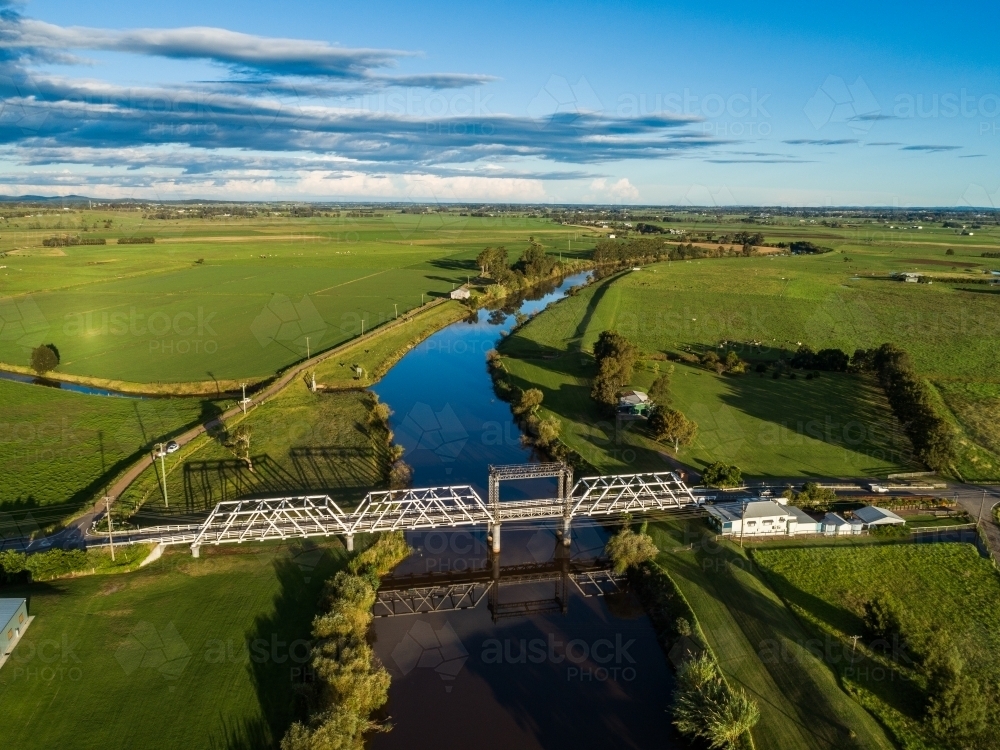 Clarence Town Road and timber truss bridge in green sunlit landscape - Australian Stock Image