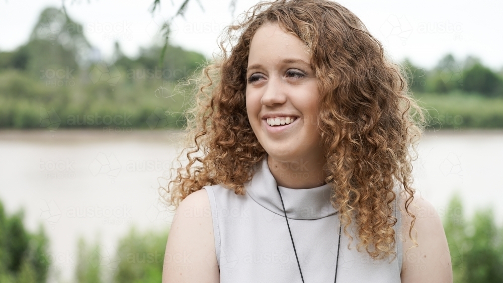 Close of red curly haired girl looking off camera - Australian Stock Image