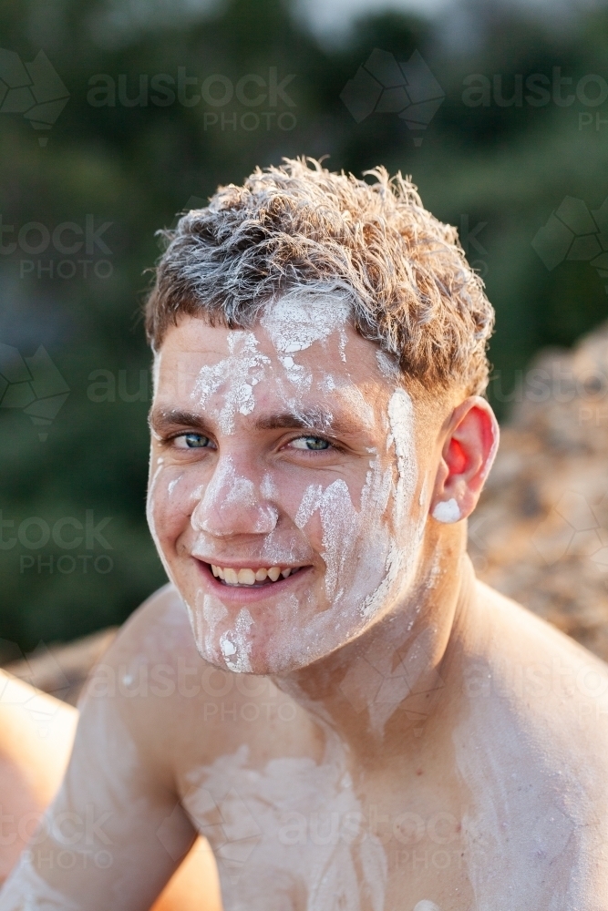 Close up face portrait of aboriginal teen in ochre body paint - Australian Stock Image