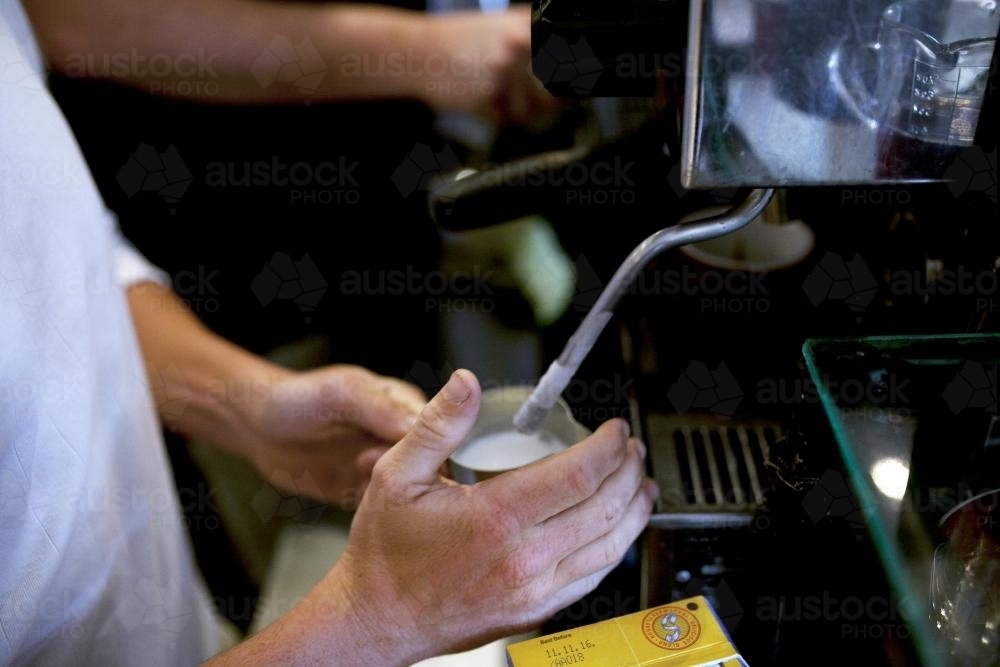 Close up of barista steaming milk - Australian Stock Image