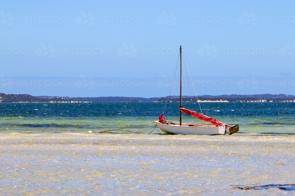 Close up of boat anchored in shallow water - Australian Stock Image