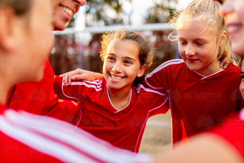 Close-up of female tween football team players in a huddle preparing for a game - Australian Stock Image