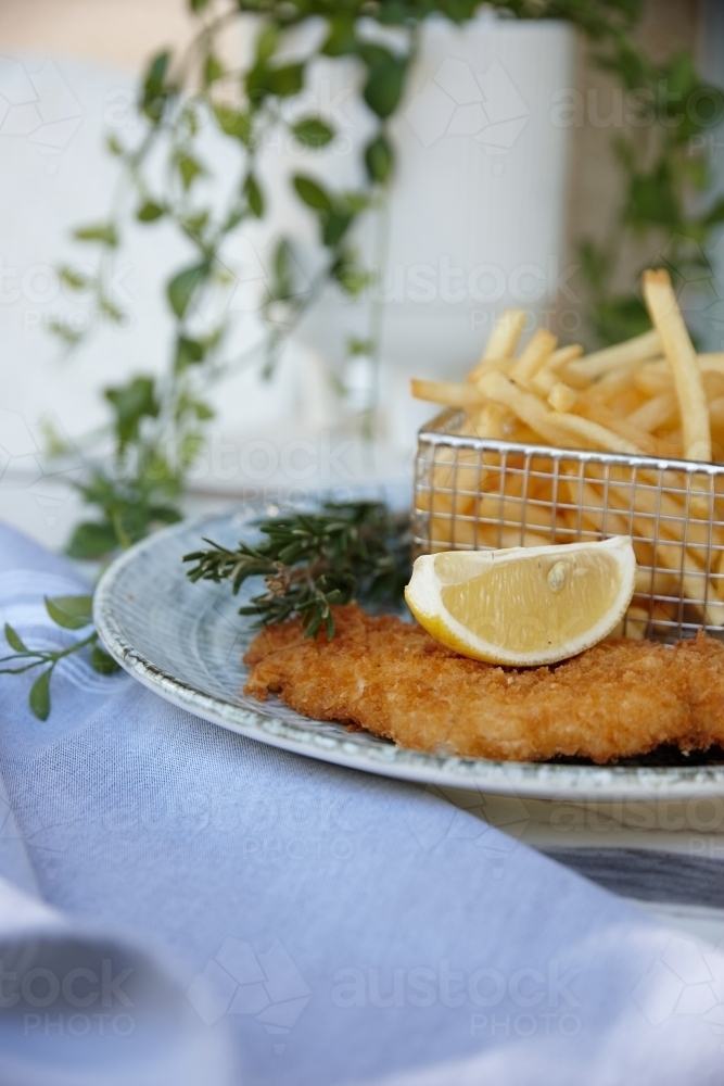 Close up of fish and chips with lemon slice on plate - Australian Stock Image