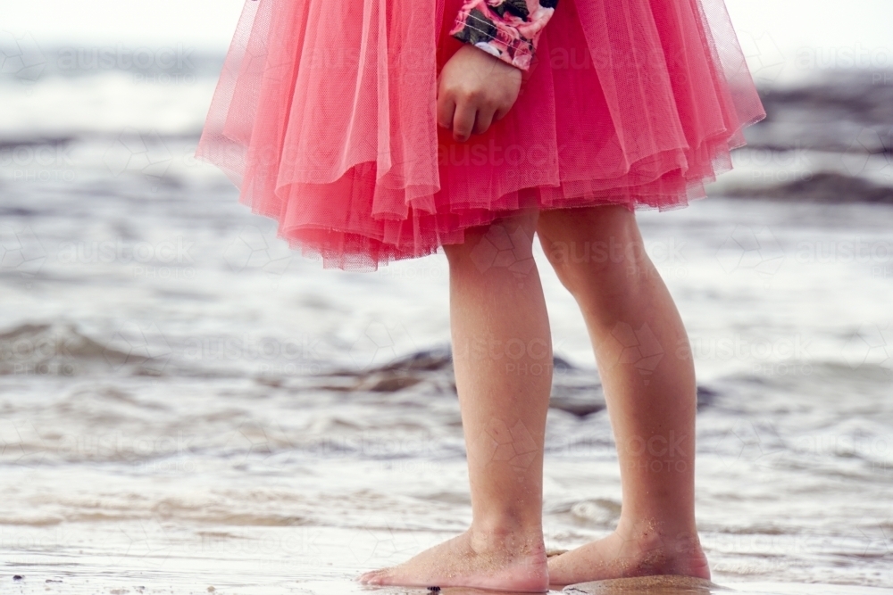 Close up of five year olds feet and legs on beach - Australian Stock Image