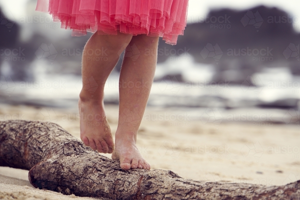 Close up of five year olds feet walking on log - Australian Stock Image