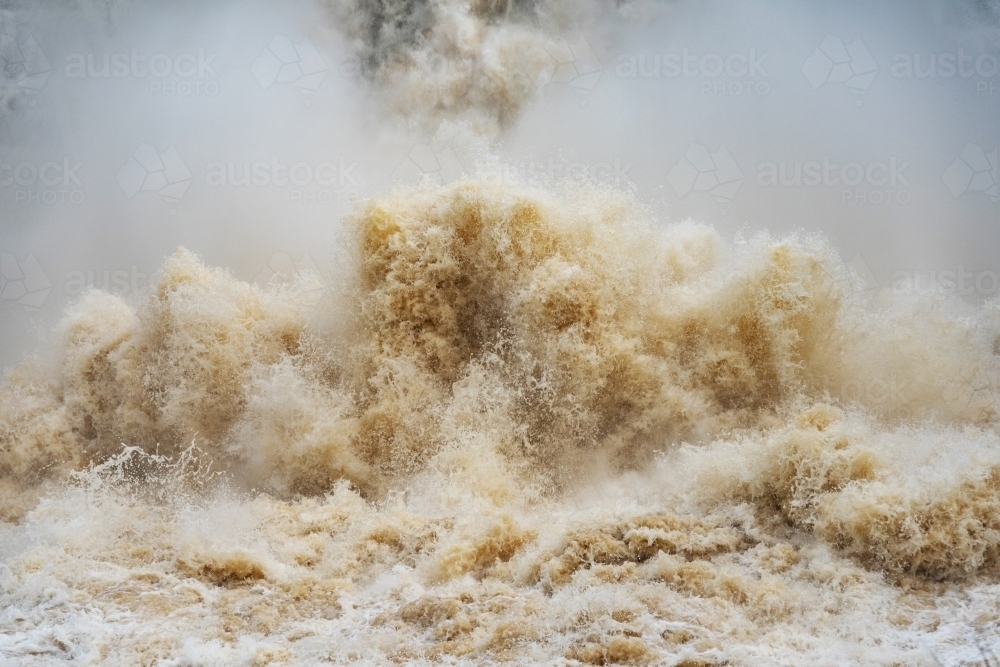 Close up of gushing water spraying out from over full dam. - Australian Stock Image