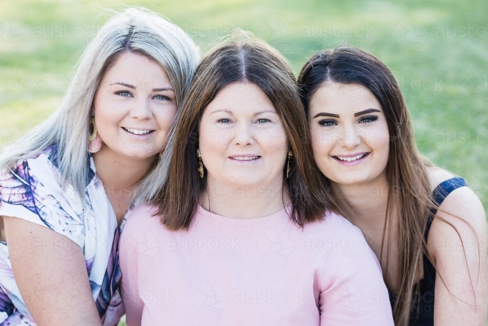 Close up of mother with two daughters smiling - Australian Stock Image