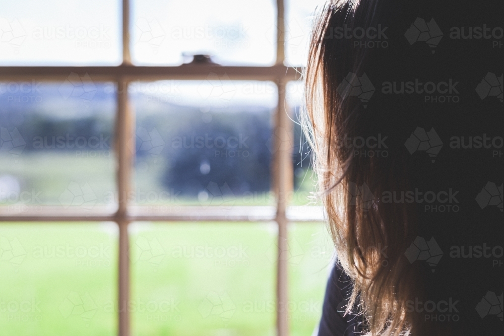 Close-up of person looking outside window in countryside - Australian Stock Image