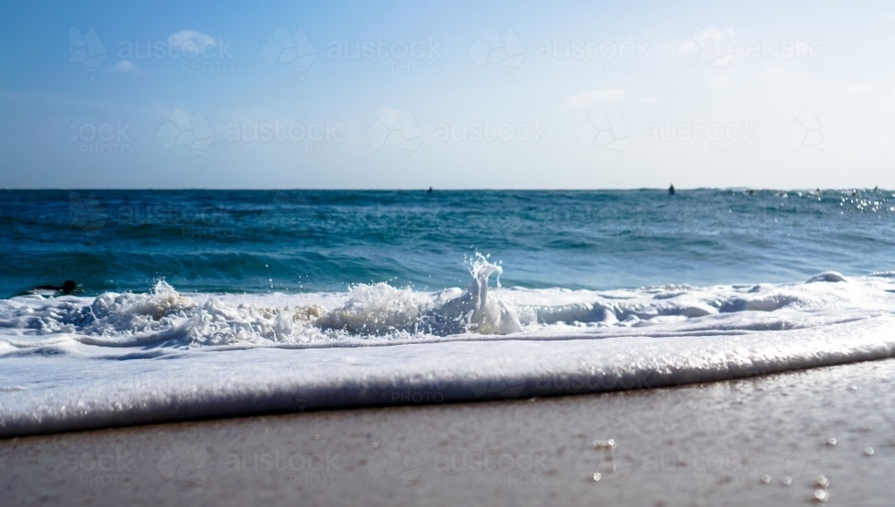 Close up of surf rolling in on sand - Australian Stock Image