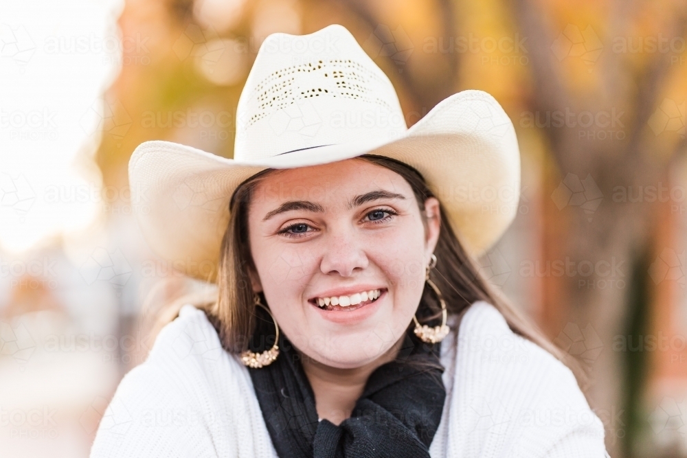 Close up of teenage girl wearing hat and scarf smiling happy - Australian Stock Image