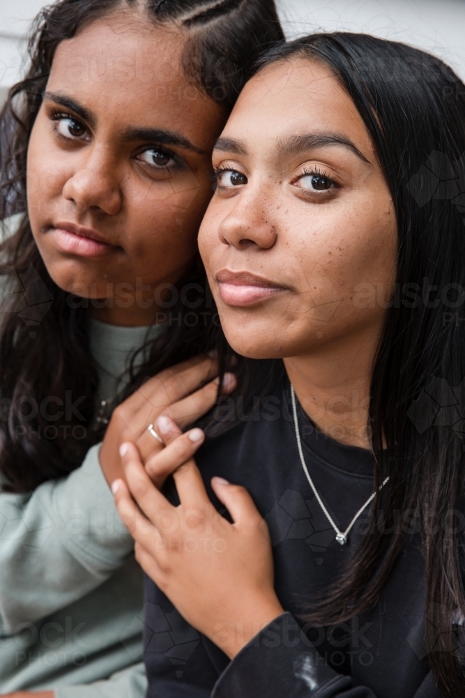 Close-up of two Aboriginal girls hugging - Australian Stock Image