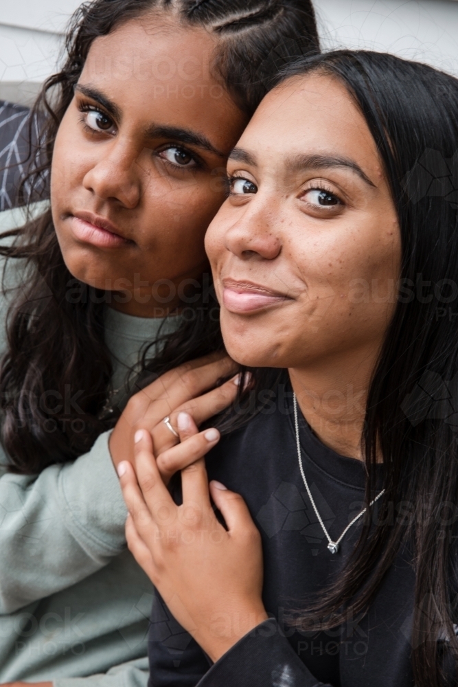 Close-up of two Aboriginal girls hugging - Australian Stock Image