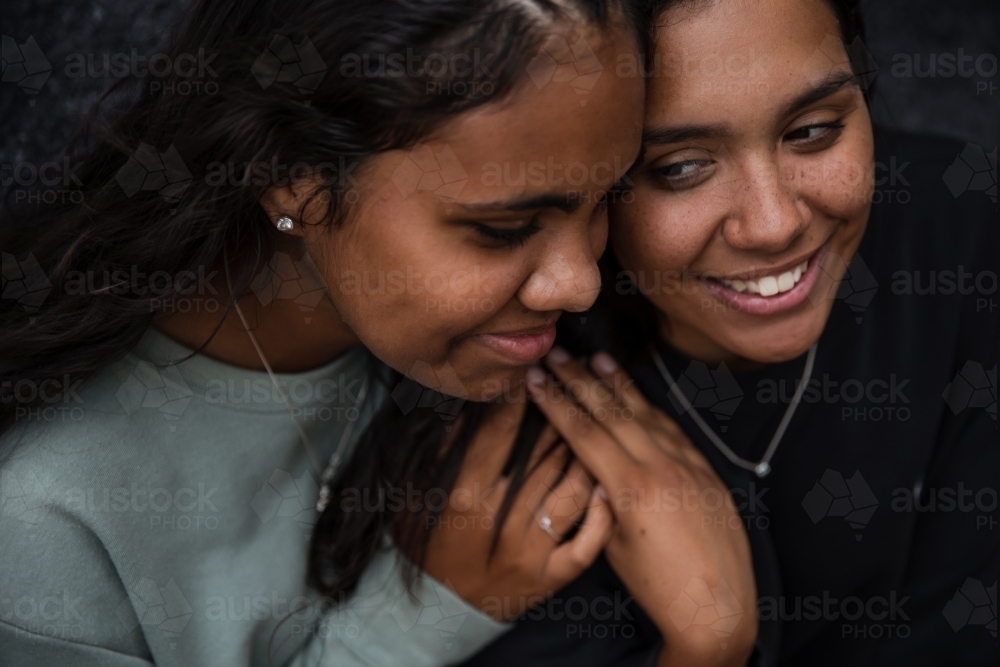 Close-up of two Aboriginal girls hugging - Australian Stock Image