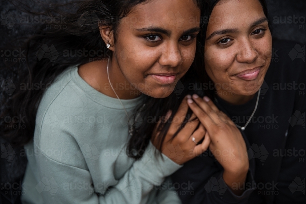 Close-up of two Aboriginal girls hugging - Australian Stock Image