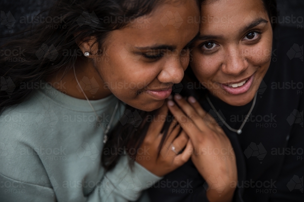 Close-up of two Aboriginal girls hugging - Australian Stock Image