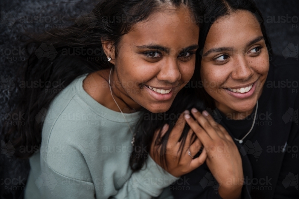 Close-up of two Aboriginal girls hugging - Australian Stock Image