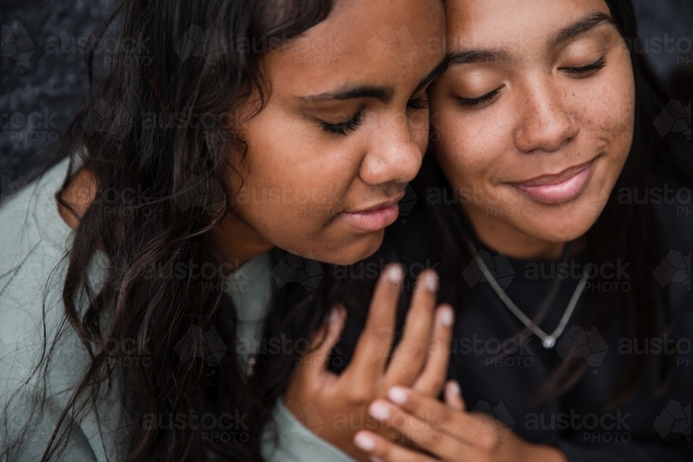 Close-up of two Aboriginal girls hugging - Australian Stock Image