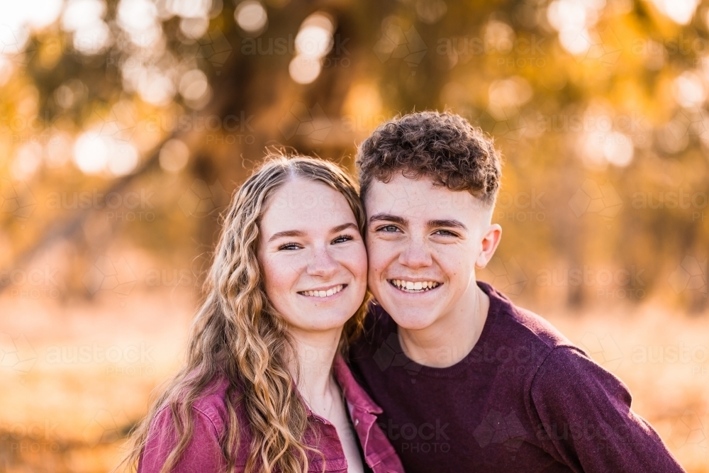 Close up of two teenagers with faces close together outside smiling - Australian Stock Image