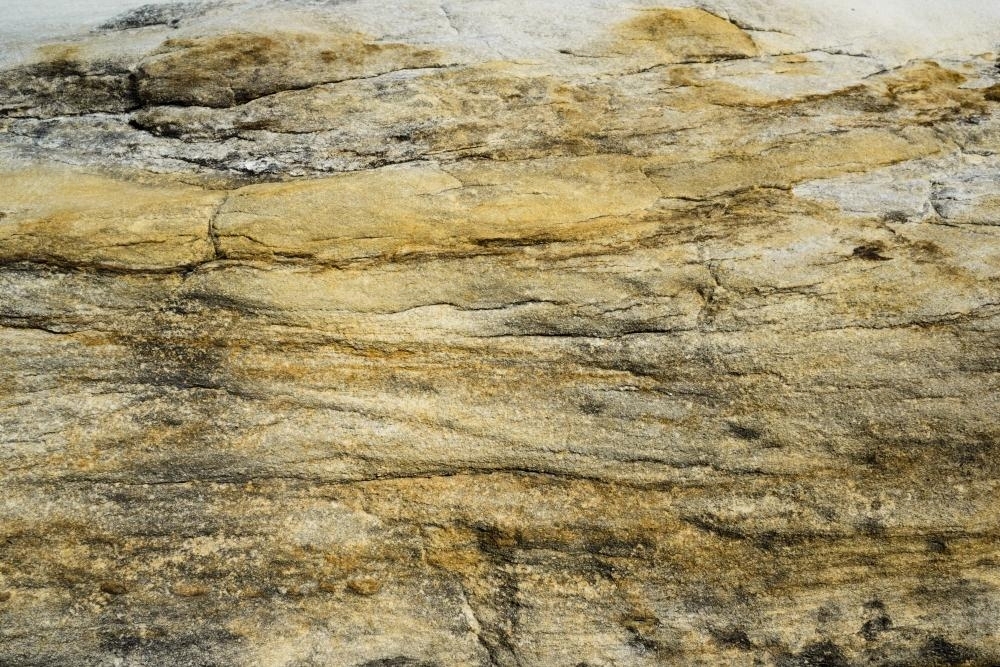 Close up of yellow horizontal striped rock with cracks - Australian Stock Image