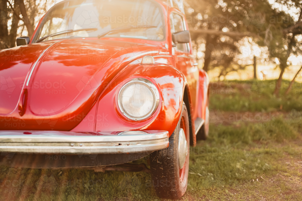 Close up on headlights of vibrant red vintage car - Australian Stock Image