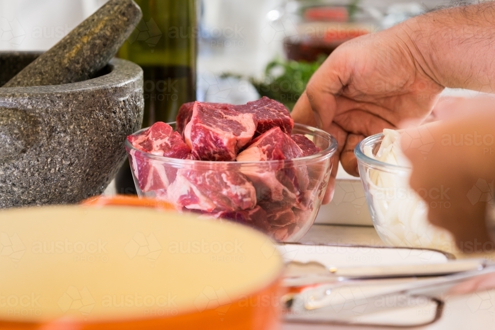 Close up photo of raw beef in a glass bowl cut into medium sized portions - Australian Stock Image